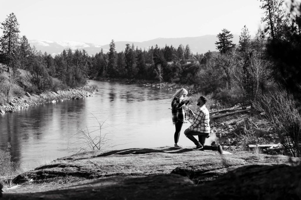 Couple getting engaged with view of spokane river in the background